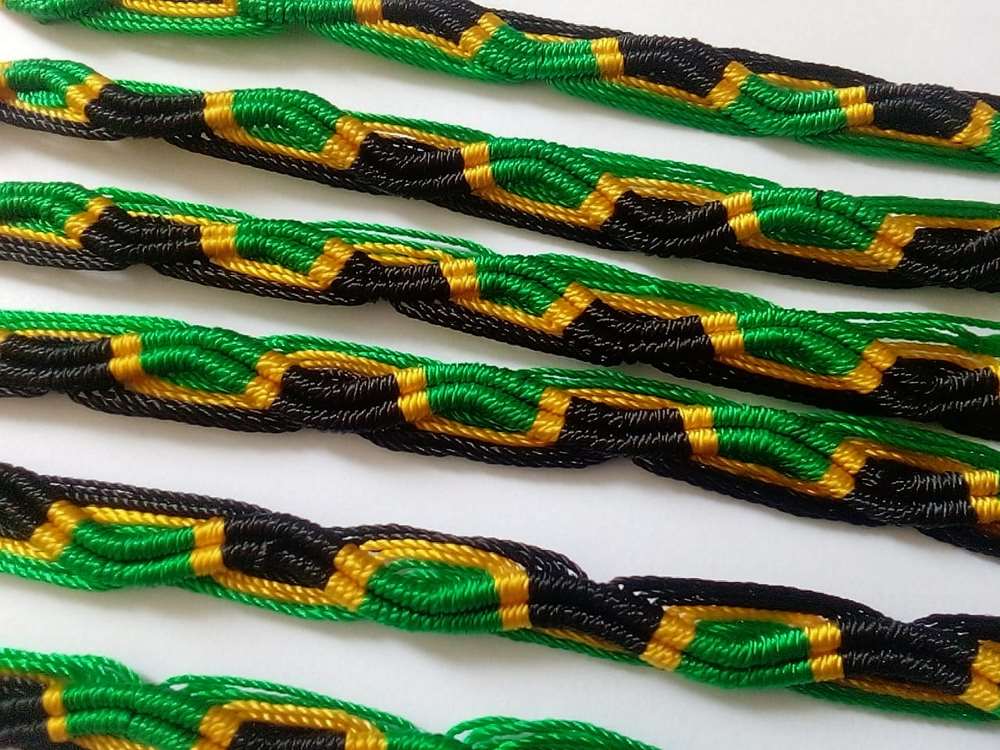 Green, black, and yellow braided bracelets on a white background