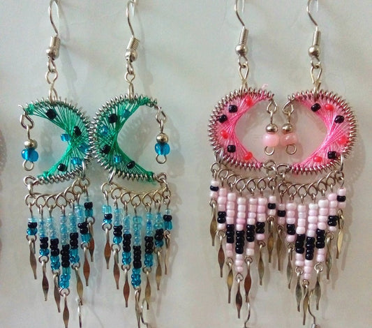 Handmade bohemian crescent moon and star dangle earrings displayed on a light background. The earrings feature colorful crescent moons, beaded fringe, and dangling silver colored ends.