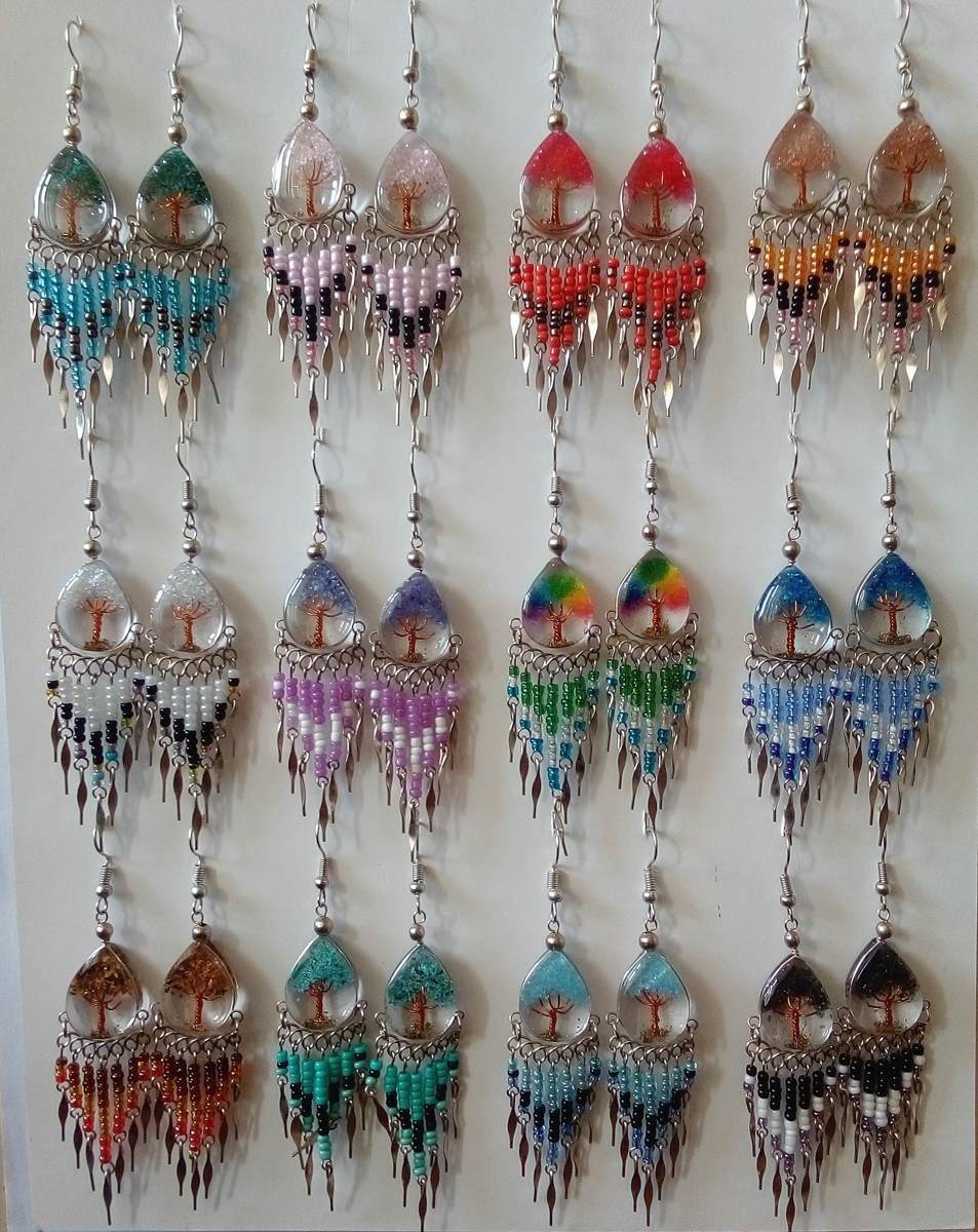 Peruvian handmade beaded dangle earringsl. Each pair features a clear resin top containing a small tree of life design, decorated with colorful beads in various patterns and color combinations.